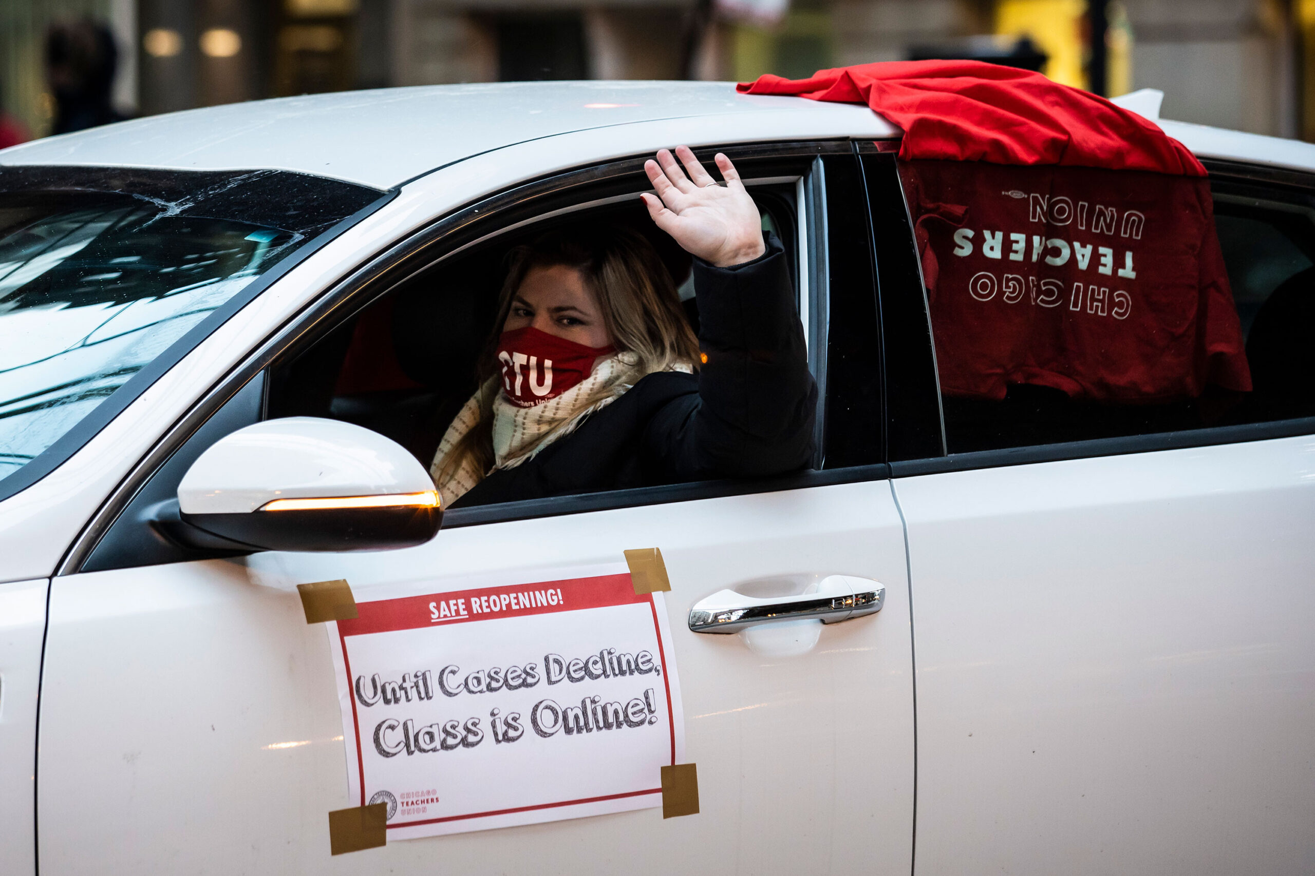 Members of the Chicago Teachers Union and supporters stage a car caravan protest outside City Hall
