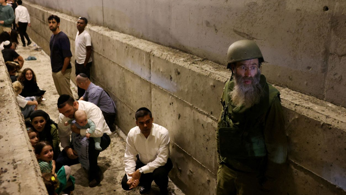 People take shelter during an air raid siren after Iran fired a salvo of ballistic missiles at Israel on October 1.