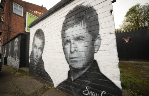 A mural depicting Liam and Noel Gallagher by artist Snow Graffiti adorns a wall at the Coach and Horses pub in Whitefield on October 21