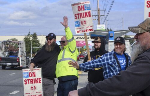 Union machinists wave signs next to the company's factory in Everett