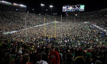 Ducks fans rush the field after Oregon beat the Ohio State Buckeyes in Eugene