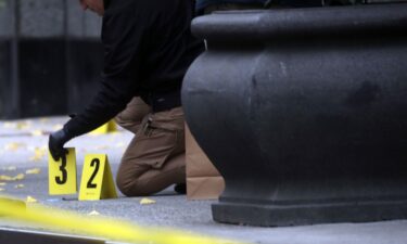 Police place bullet casing markers outside of a Hilton Hotel in Midtown Manhattan in New York