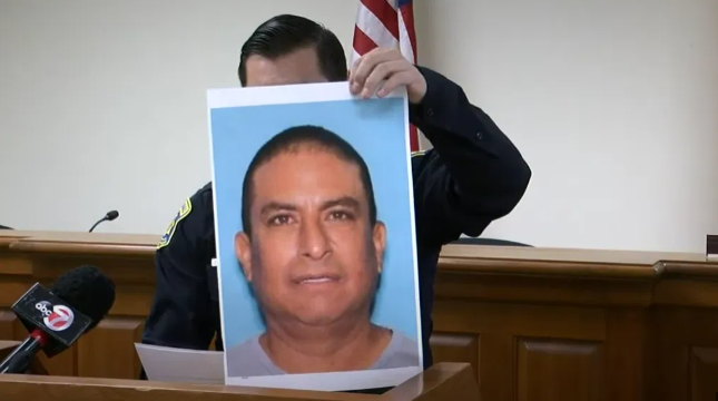 Law enforcement officials hold up a picture of Sandoval during a news conference while the manhunt was still ongoing.