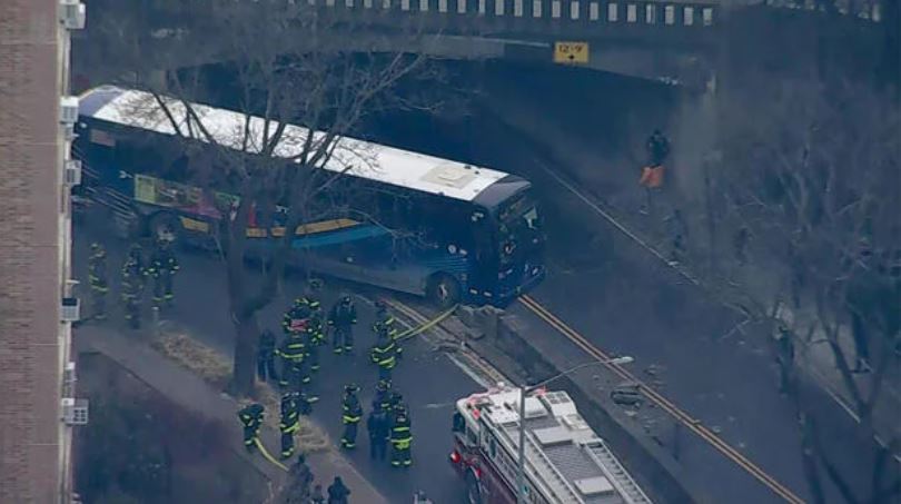 <i>WCBS/WLNY via CNN Newsource</i><br/>The BxM1 bus could be seen partially hanging from the roadway over another road after smashing through a wall.