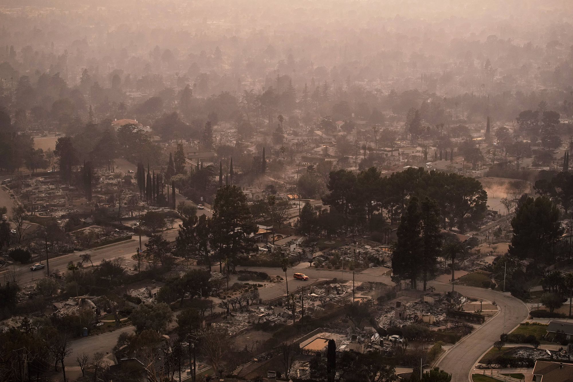 <i>John Locher/AP via CNN Newsource</i><br/>Smoke lingers over a neighborhood devastated by the Eaton Fire