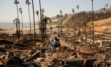 Kevin Marshall sifts through his mother's fire-ravaged property in the Pacific Palisades neighborhood of Los Angeles on January 11.