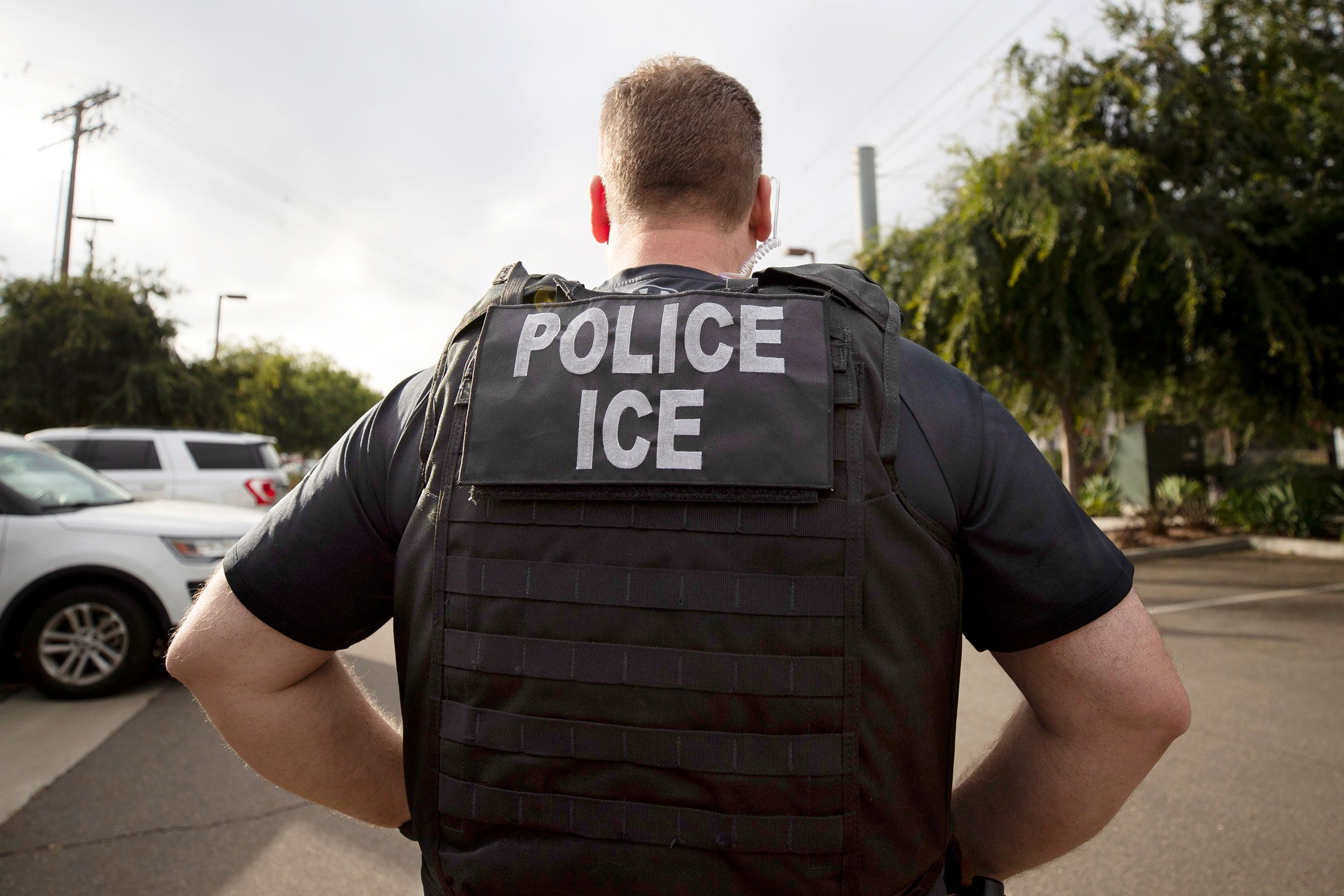 <i>Gregory Bull/AP via CNN Newsource</i><br/>An Immigration and Customs Enforcement officer looks on during an operation in Escondido