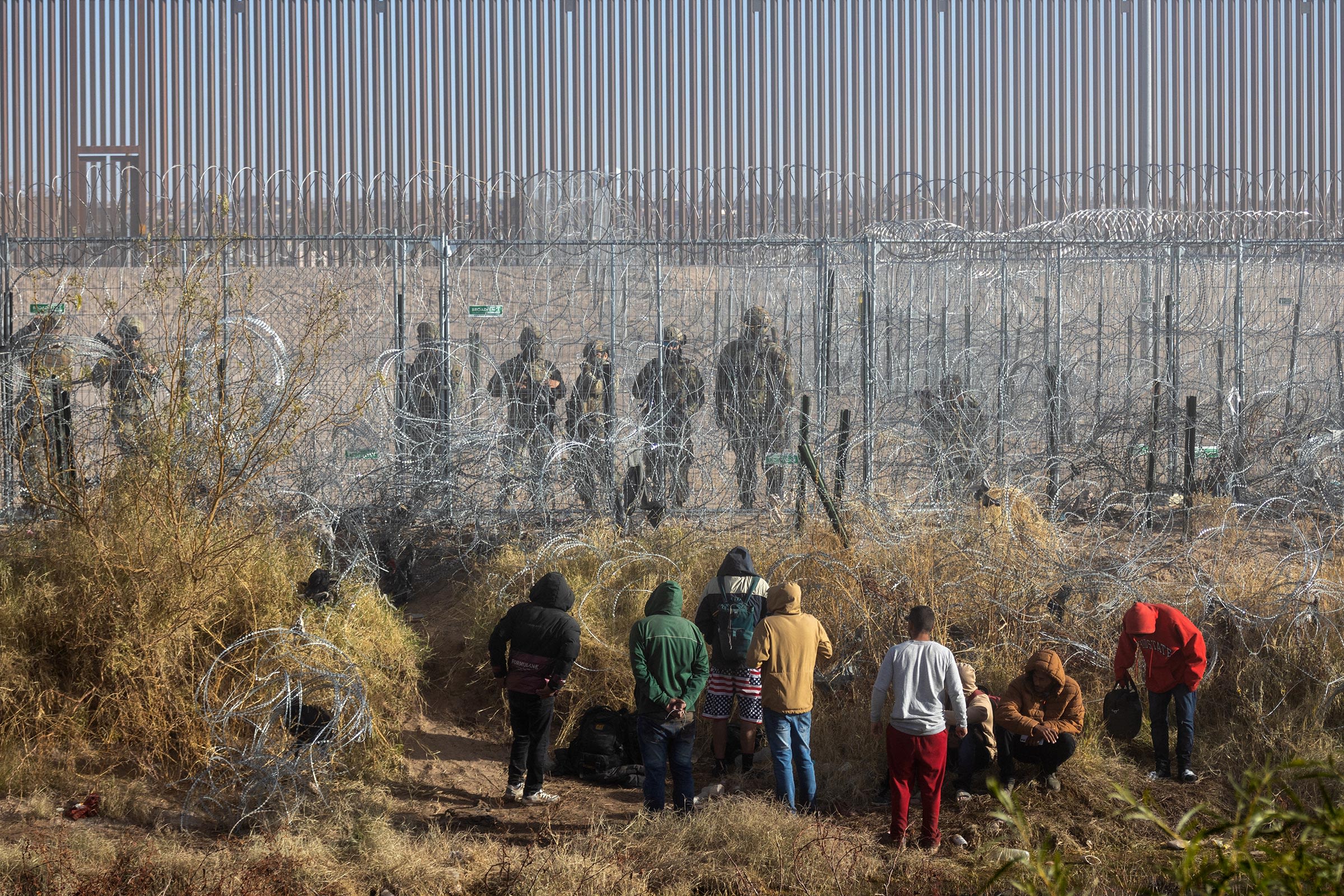 Migrants walk near the Rio Grande along the US-Mexico border in Juarez, Chihuahua state, Mexico, on December 18, 2024.