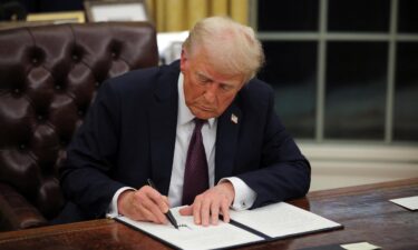 President Donald Trump signs documents as he issues executive orders and pardons for January 6 defendants in the Oval Office at the White House on Inauguration Day in Washington