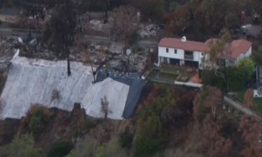 Tarping is placed on steep hillsides below homes and areas where homes were burned down in the Palisades Fire in January 2025.