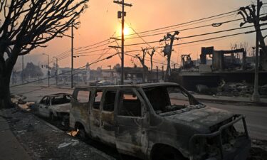 Charred vehicles are seen along a road after the passage of the Palisades Fire in Pacific Palisades