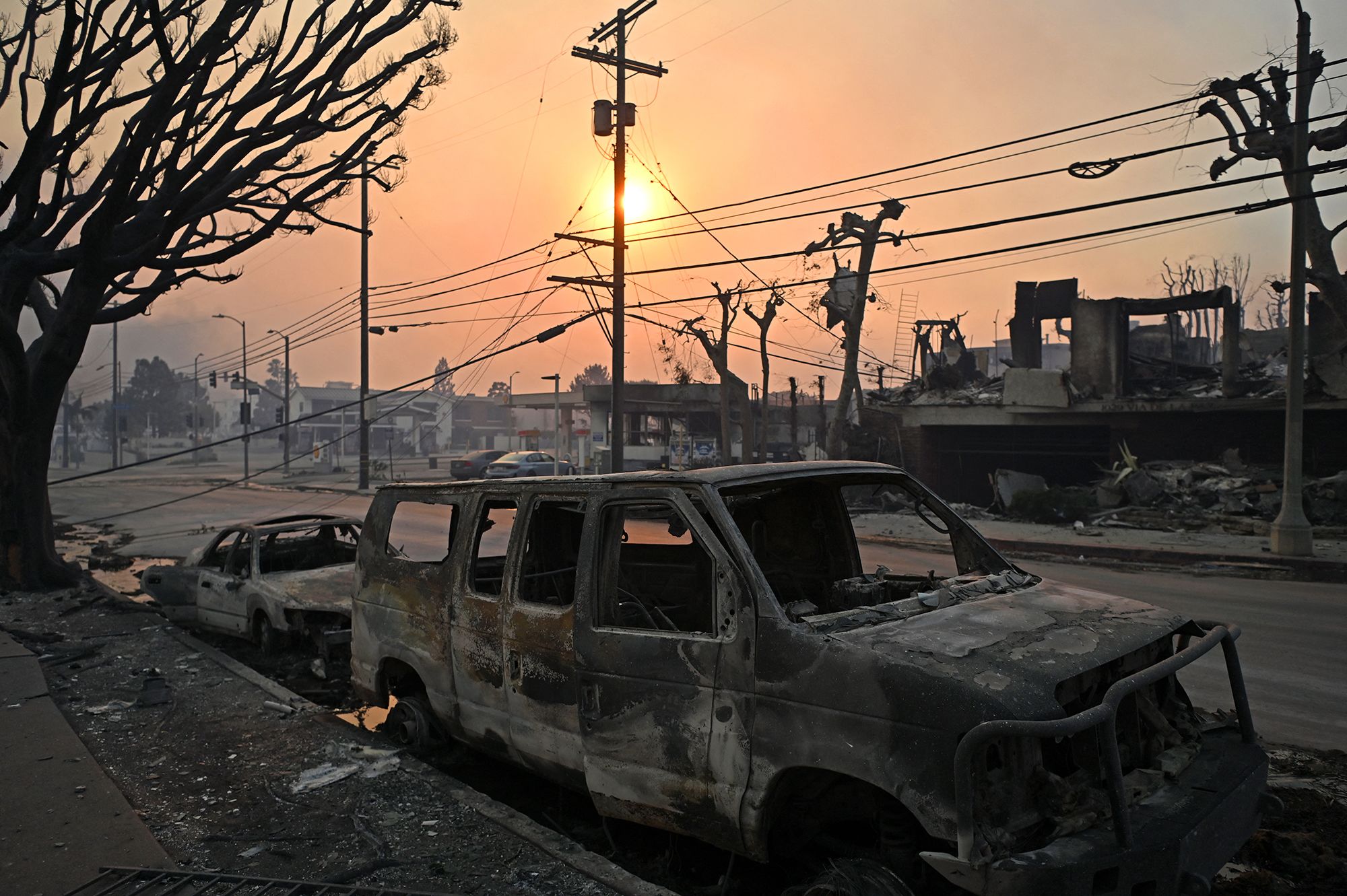 <i>Agustin Paullier/AFP/Getty Images via CNN Newsource</i><br/>Charred vehicles are seen along a road after the passage of the Palisades Fire in Pacific Palisades