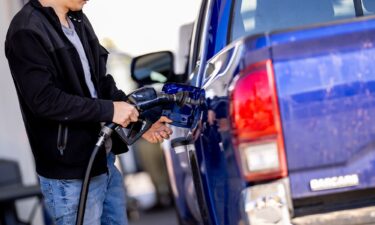 A man stops to fill up his car at a gas station in Washington