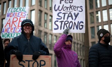 Protesters rally outside of the Theodore Roosevelt Federal Building headquarters of the US Office of Personnel Management in Washington