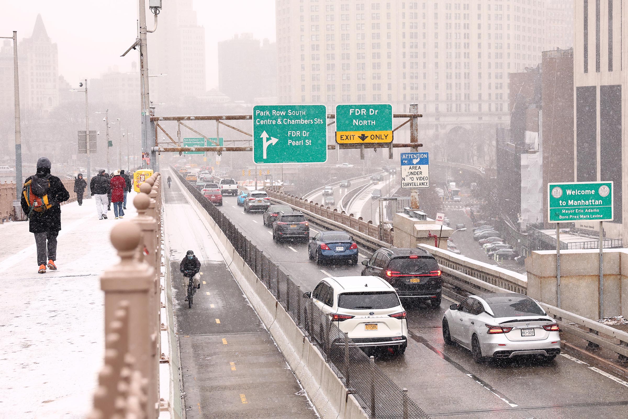 <i>Michael M. Santiago/Getty Images via CNN Newsource</i><br/>People walk along the Brooklyn Bridge as cars drive into Manhattan on January 6 in New York City.