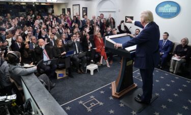 President Donald Trump takes reporters' questions during a White House briefing. The Associated Press is suing three Trump administration officials.
