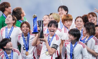 Japan's Saki Kumagai holds the SheBelieves Cup trophy after victory against the US.