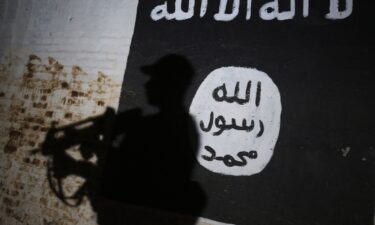 A member of the Iraqi forces walks past a mural bearing the logo of the Islamic State (IS) group in a tunnel that was reportedly used as a training centre by the jihadists