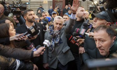 Calin Georgescu waves to supporters after leaving a court in Bucharest