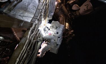 Suni Williams is seen during a six-hour spacewalk outside the International Space Station. A SpaceX Dragon crew spacecraft (top right) can be seen docked to the space station's Harmony module.