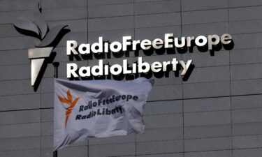A flag and a sign of Radio Free Europe/Radio Liberty is pictured. The leaders of several US-funded international networks have instructed their organizations to continue broadcasting