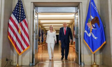 President Donald Trump walks with US Attorney General Pam Bondi as he visits the Department of Justice to address its workers