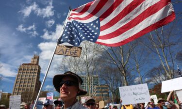A protester carries a US flag upside down during a "Hands Off!" protest in Asheville