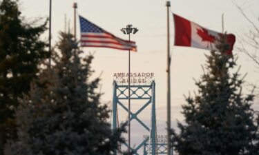 The US and Canadian flags fly on the Canadian side of the Ambassador Bridge in Windsor
