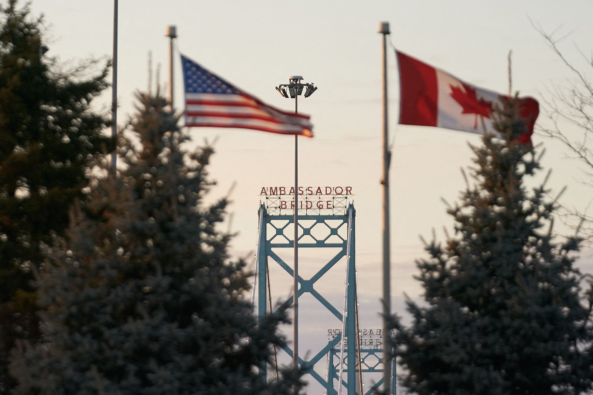 <i>Geoff Robins/AFP/Getty Images via CNN Newsource</i><br/>The US and Canadian flags fly on the Canadian side of the Ambassador Bridge in Windsor