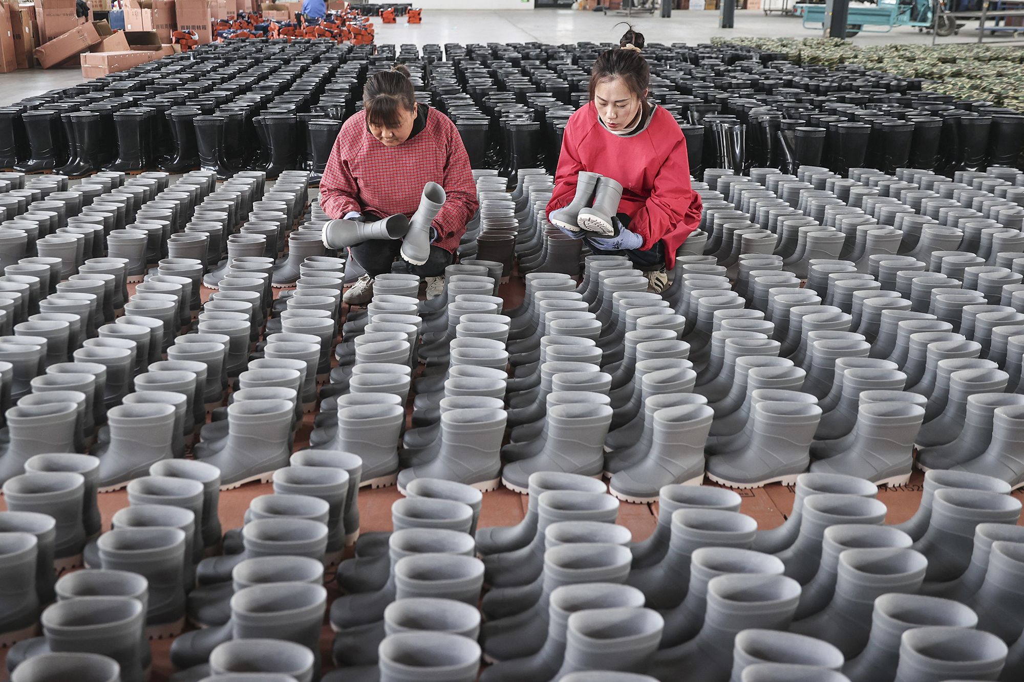 <i>STR/AFP/Getty Images via CNN Newsource</i><br/>Employees check rain boots for export at a shoe factory in Lianyungang