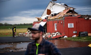 Jesse Furman is handed one of her belongings by Brayden McLemore near her destroyed trailer in Selmer