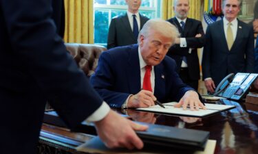 President Donald Trump signs a executive order as Treasury Secretary Scott Bessent