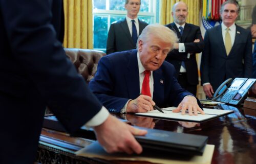 President Donald Trump signs a executive order as Treasury Secretary Scott Bessent