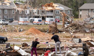 Jesse Furman is handed one of her belongings by Brayden McLemore near her destroyed trailer in Selmer