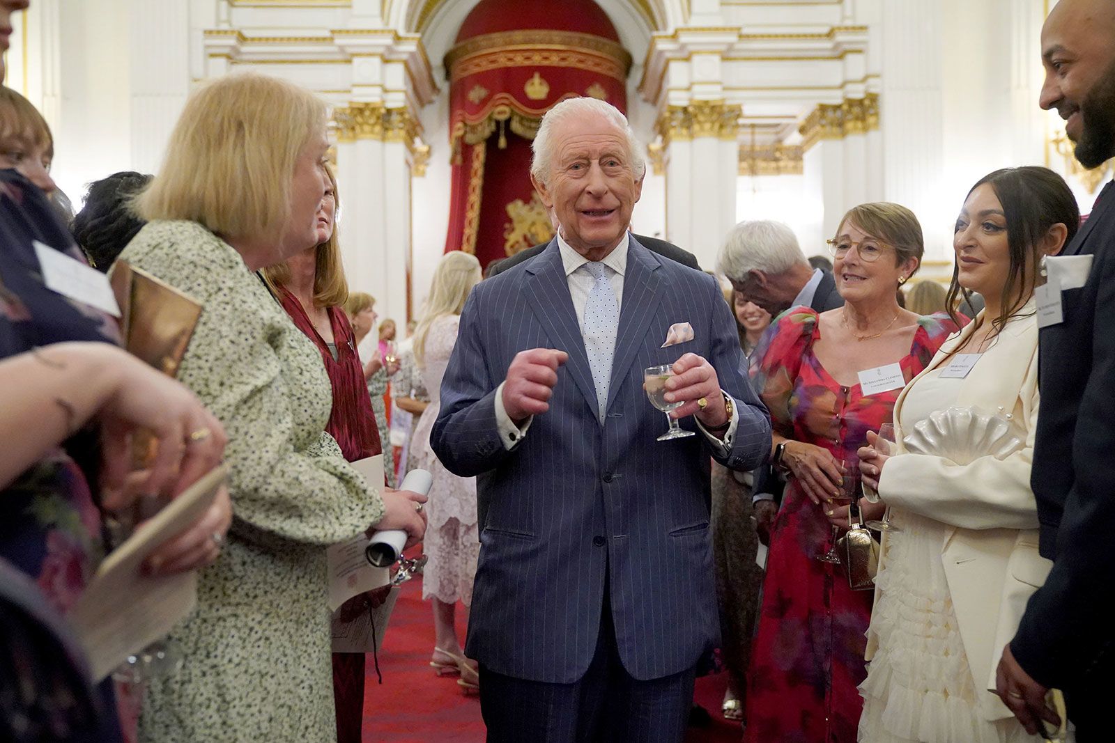<i>WPA Pool/Getty Images via CNN Newsource</i><br/>King Charles III speaks to guests during a reception in celebration of community-based initiatives raising awareness about cancer and supporting those living with cancer at Buckingham Palace on April 30