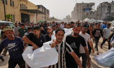 Palestinians carry the bodies of their relatives killed in an Israeli airstrike