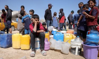 Palestinians attempt to collect water at a camp for displaced people in Gaza City