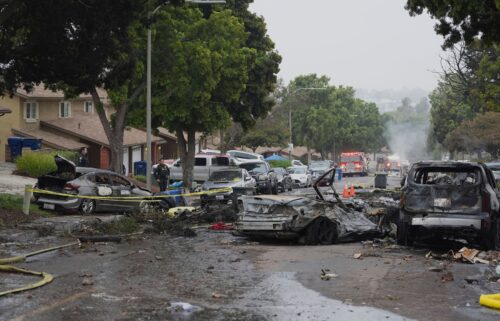 Authorities work the scene where a small plane crashed into a San Diego neighborhood