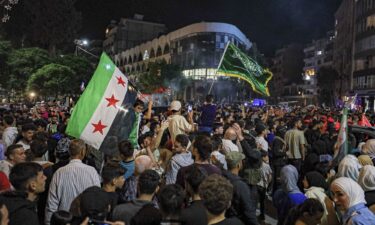 People gather outside the Commercial Bank of Syria