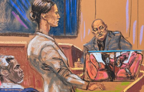 Sean "Diddy" Combs watches as prosecutor Christy Slavik questions Los Angeles fire arson investigator Lance Jimenez near a photo of the interior of Scott Mescudi's damaged car.