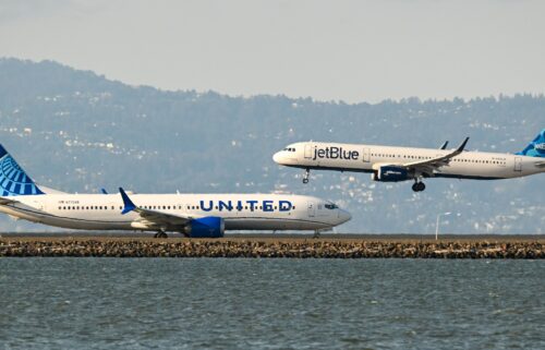 A United Airlines plane prepares for takeoff as a JetBlue plane lands at San Francisco International Airport in 2023.