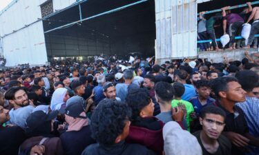 People gather as Palestinians receive aid supplies from the US-backed Gaza Humanitarian Foundation