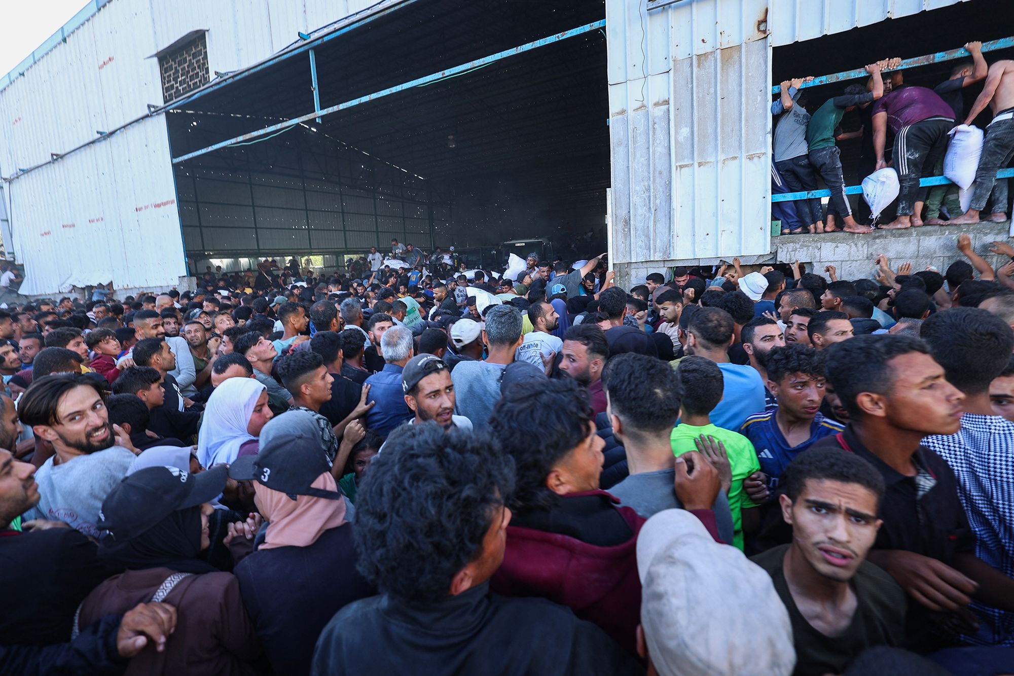 <i>Ramadan Abed/Reuters via CNN Newsource</i><br/>People gather as Palestinians receive aid supplies from the US-backed Gaza Humanitarian Foundation