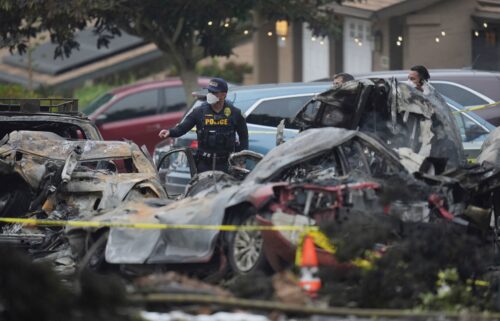 Authorities work the scene where a small plane crashed into a San Diego neighborhood early Thursday.