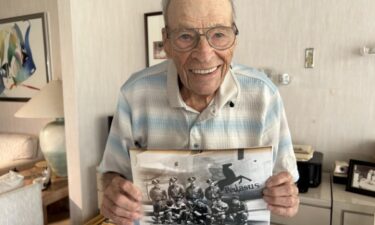 World War Two Veteran Sydney Edson holds a picture of his bomb Squadron crew.
