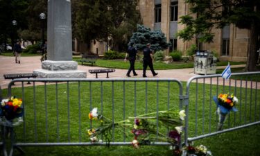 An Israeli flag is fixed to a street sign as police stand by off Pearl Street in Boulder