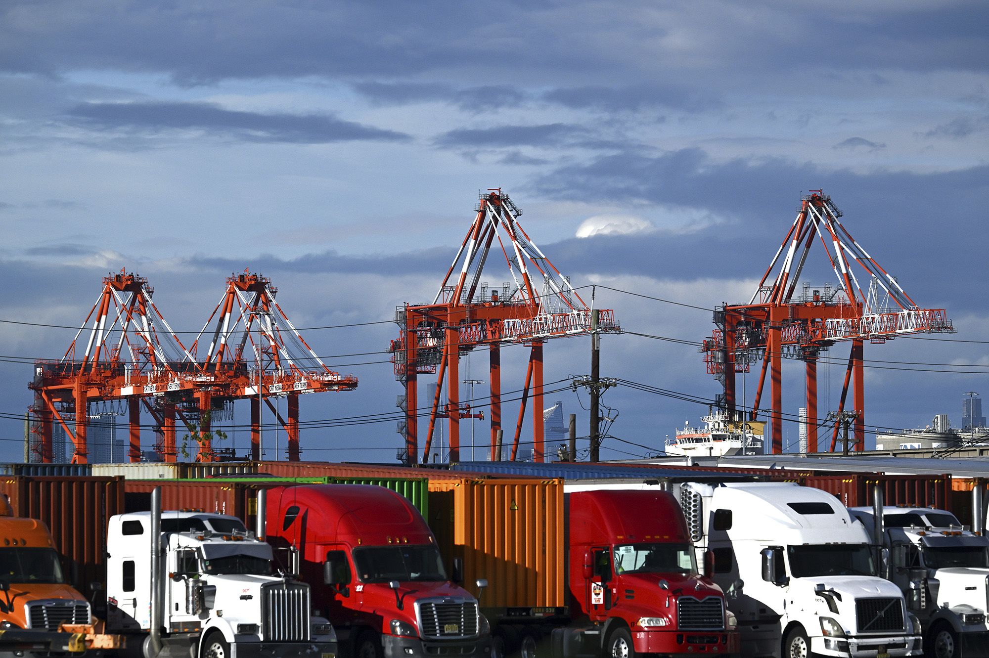 <i>Anthony Behar/Sipa USA/AP via CNN Newsource</i><br/>View of shipping cranes seen behind trucks and shipping containers at a port in Elizabeth