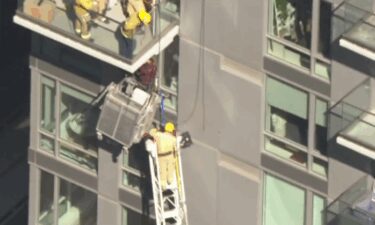 Firefighters rescued a window washer who was trapped several stories high on the side of a downtown Los Angeles high-rise apartment building on July 29.