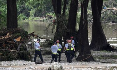 Members of a search and rescue team look for people near Camp Mystic in Hunt