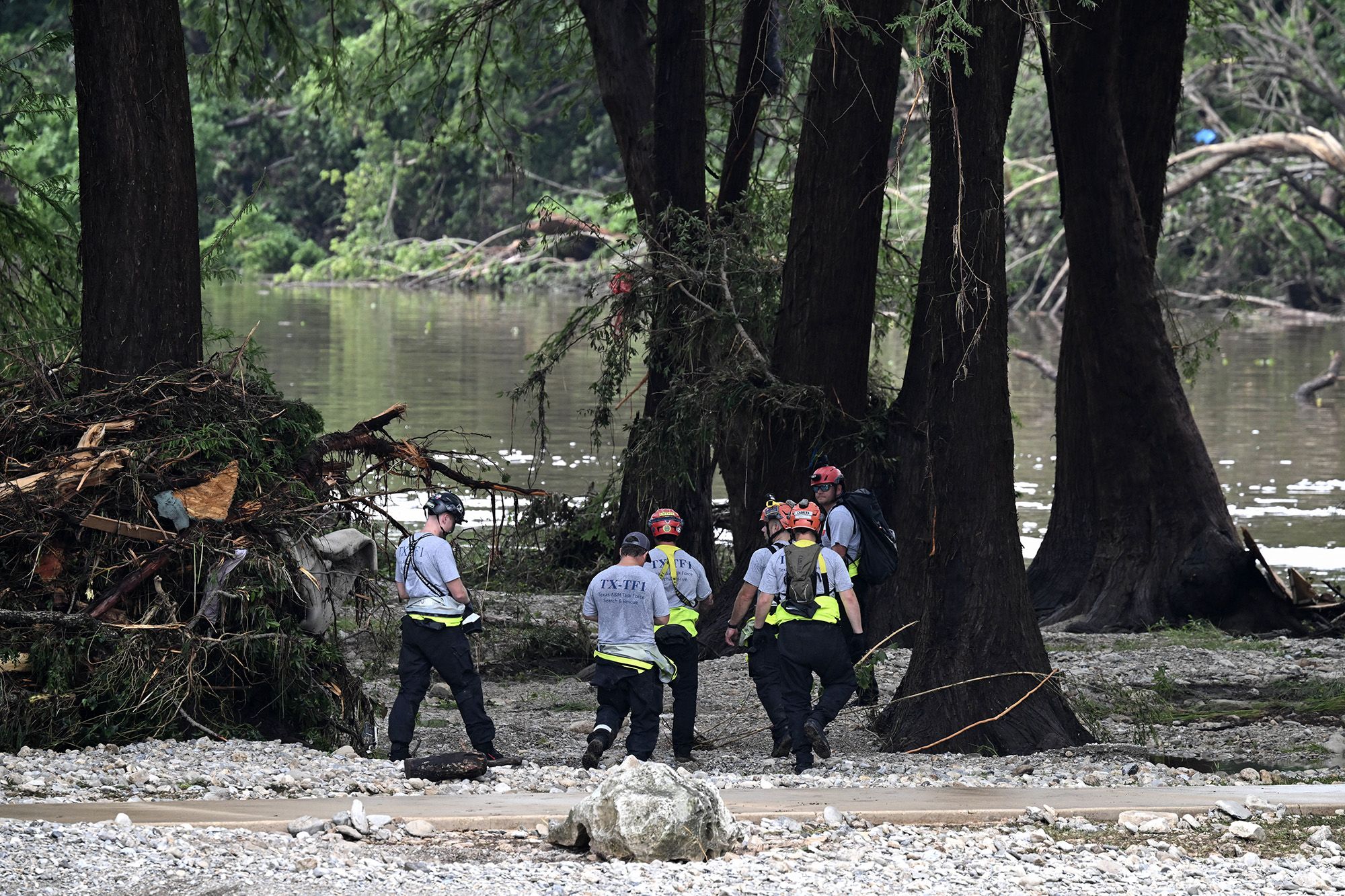 <i>Ronaldo Schemidt/AFP/Getty Images via CNN Newsource</i><br/>Members of a search and rescue team look for people near Camp Mystic in Hunt